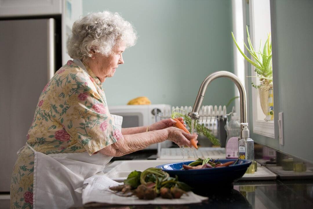 Elderly-woman-cleaning-vegetab